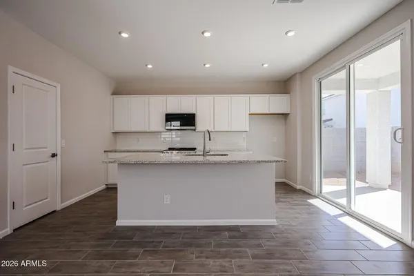 a kitchen with stainless steel appliances granite countertop a stove a sink and a microwave