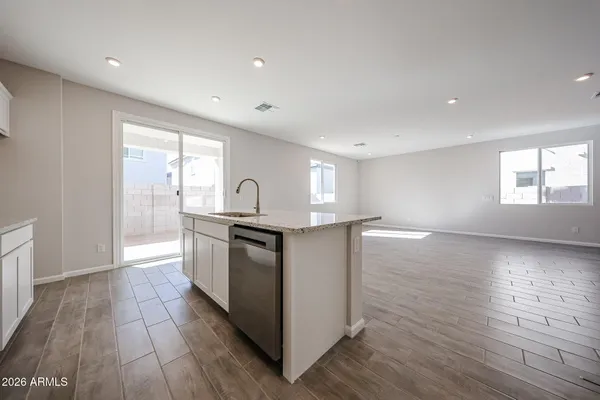 a kitchen with granite countertop a stove a sink and a microwave