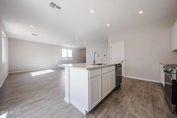 a kitchen with granite countertop a stove and wooden floor