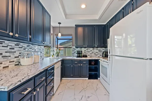 a kitchen with stainless steel appliances granite countertop a sink stove and refrigerator