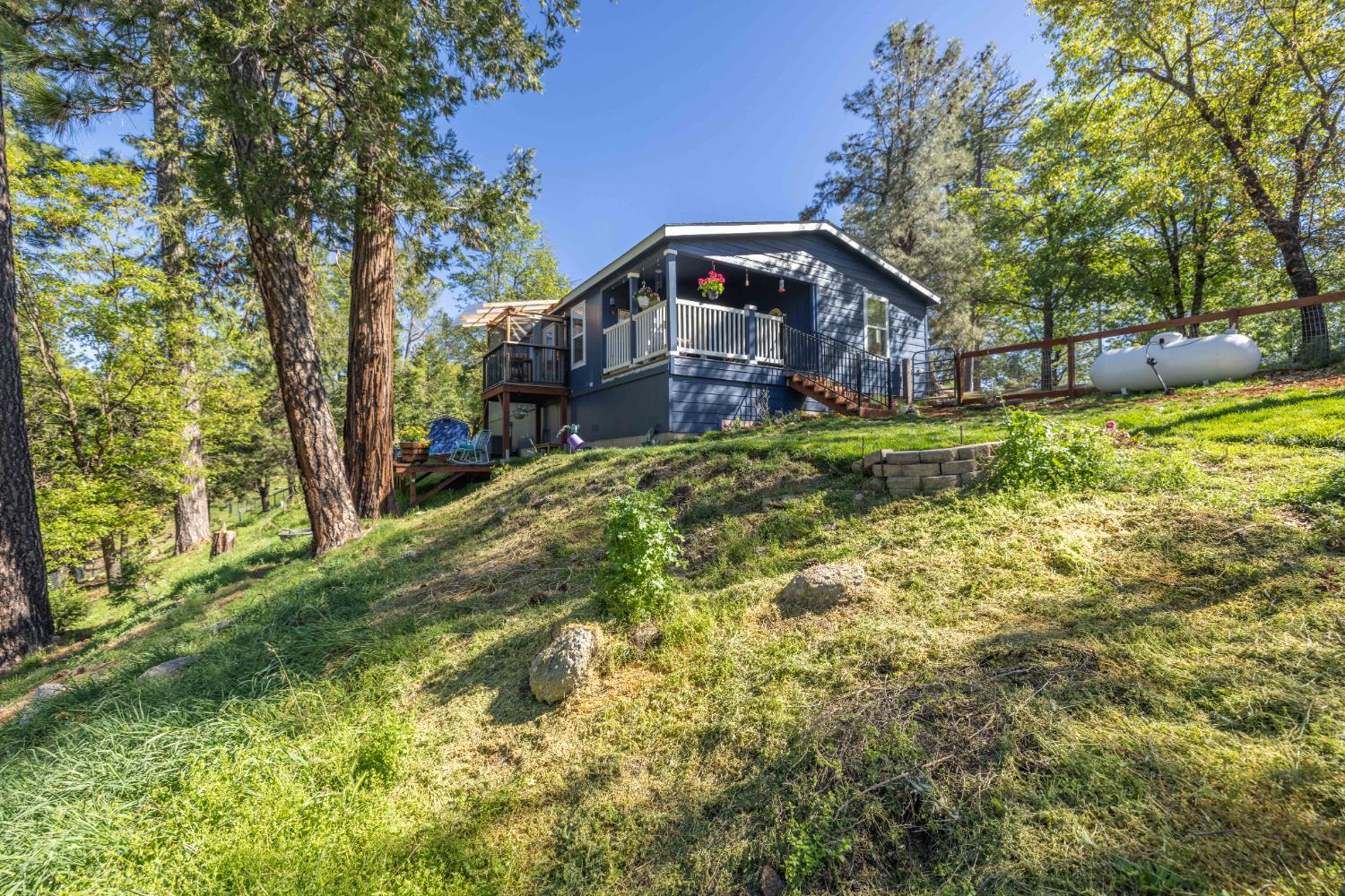 5015 Shooting Star Road Pollock Pines, CA 95726 - Photo 29 of 44 a backyard of a house with large trees and wooden fence