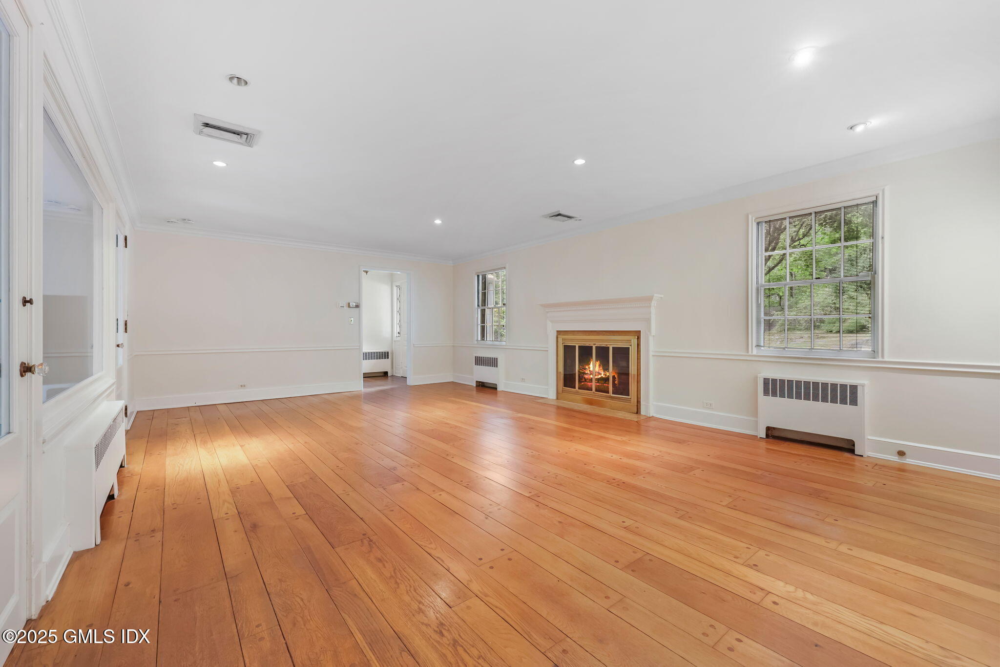 320 Cognewaugh Road Cos Cob, CT 06807 - Photo 14 of 27 an empty room with wooden floor and fireplace