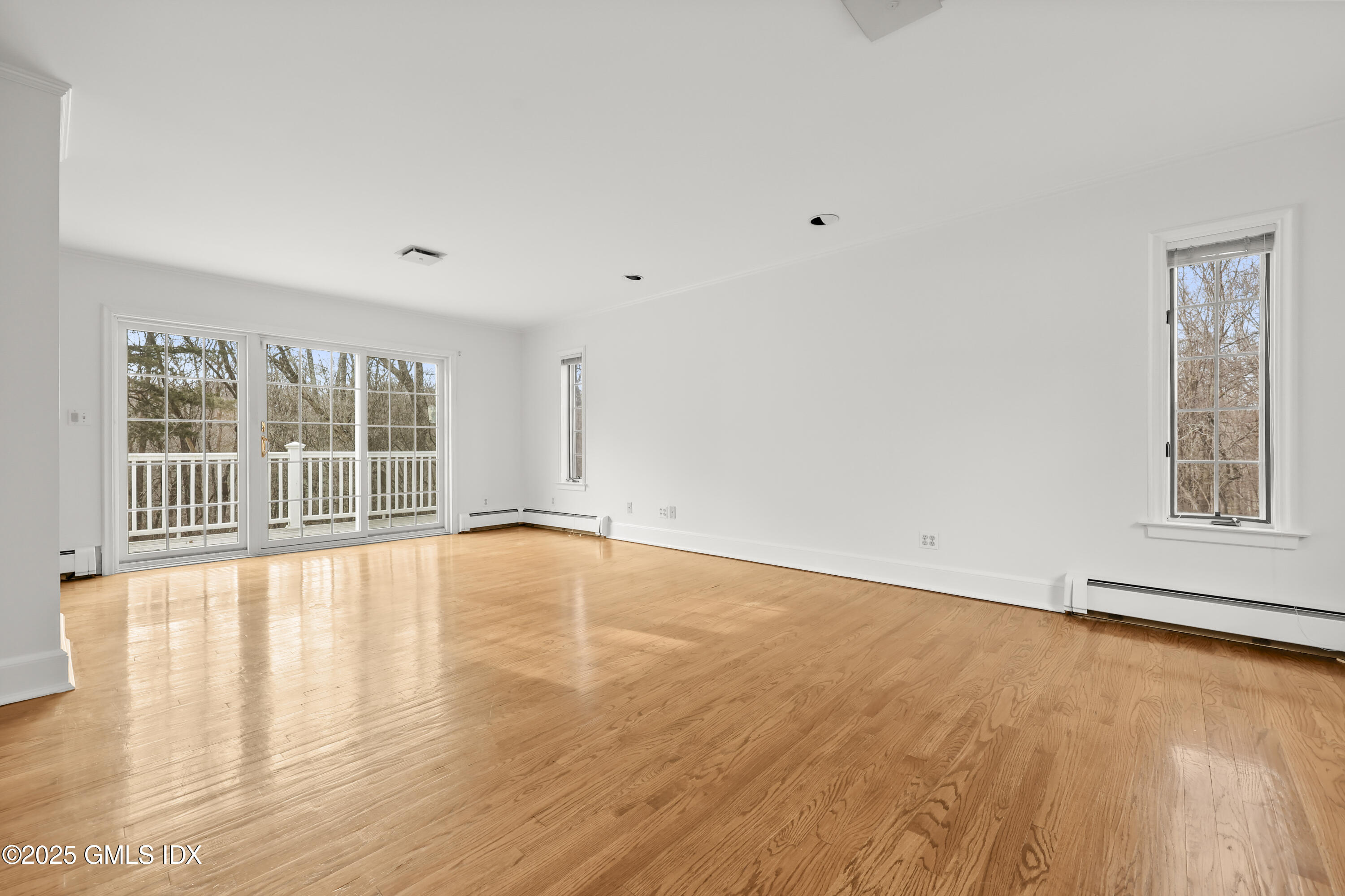 320 Cognewaugh Road Cos Cob, CT 06807 - Photo 17 of 27 an empty room with wooden floor and windows