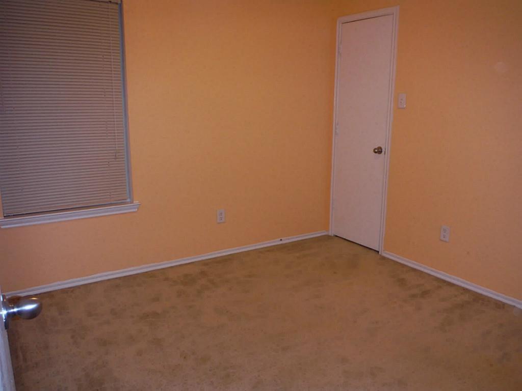 3142 Aspen Fair Trail Spring, TX 77389 - Photo 18 of 22 This photo shows a small room with softly painted walls, beige carpet, a window with closed blinds, and a white door. It's a simple, cozy space suitable for a bedroom or office.