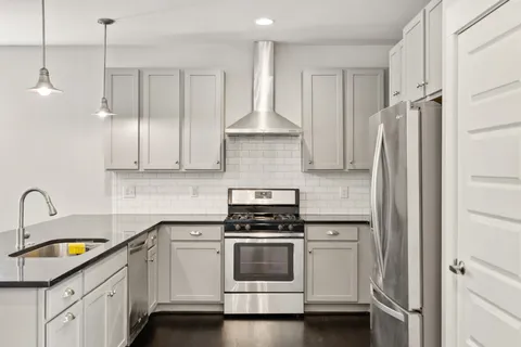 a kitchen with white cabinets and appliances