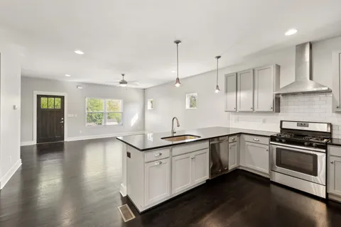a kitchen with stainless steel appliances granite countertop a sink and stove top oven