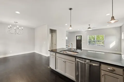 a kitchen with a sink chandelier and wooden floor