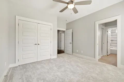an empty room with closet and fan