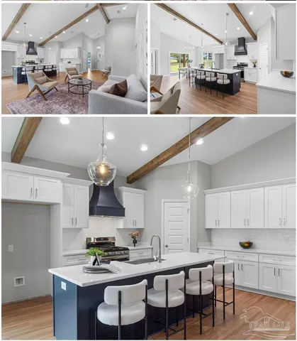 a kitchen with stainless steel appliances kitchen island granite countertop a stove a sink dishwasher and white cabinets with wooden floor