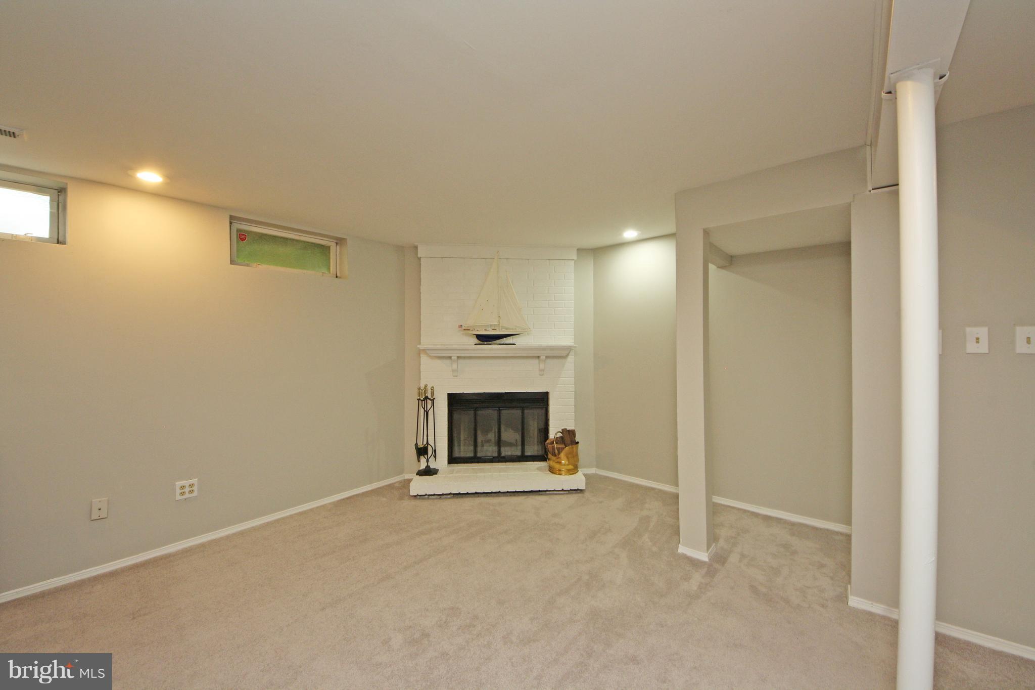 2152 Cedar Barn Way Baltimore, MD 21244 - Photo 22 of 29 a view of an empty room with a fireplace and a window
