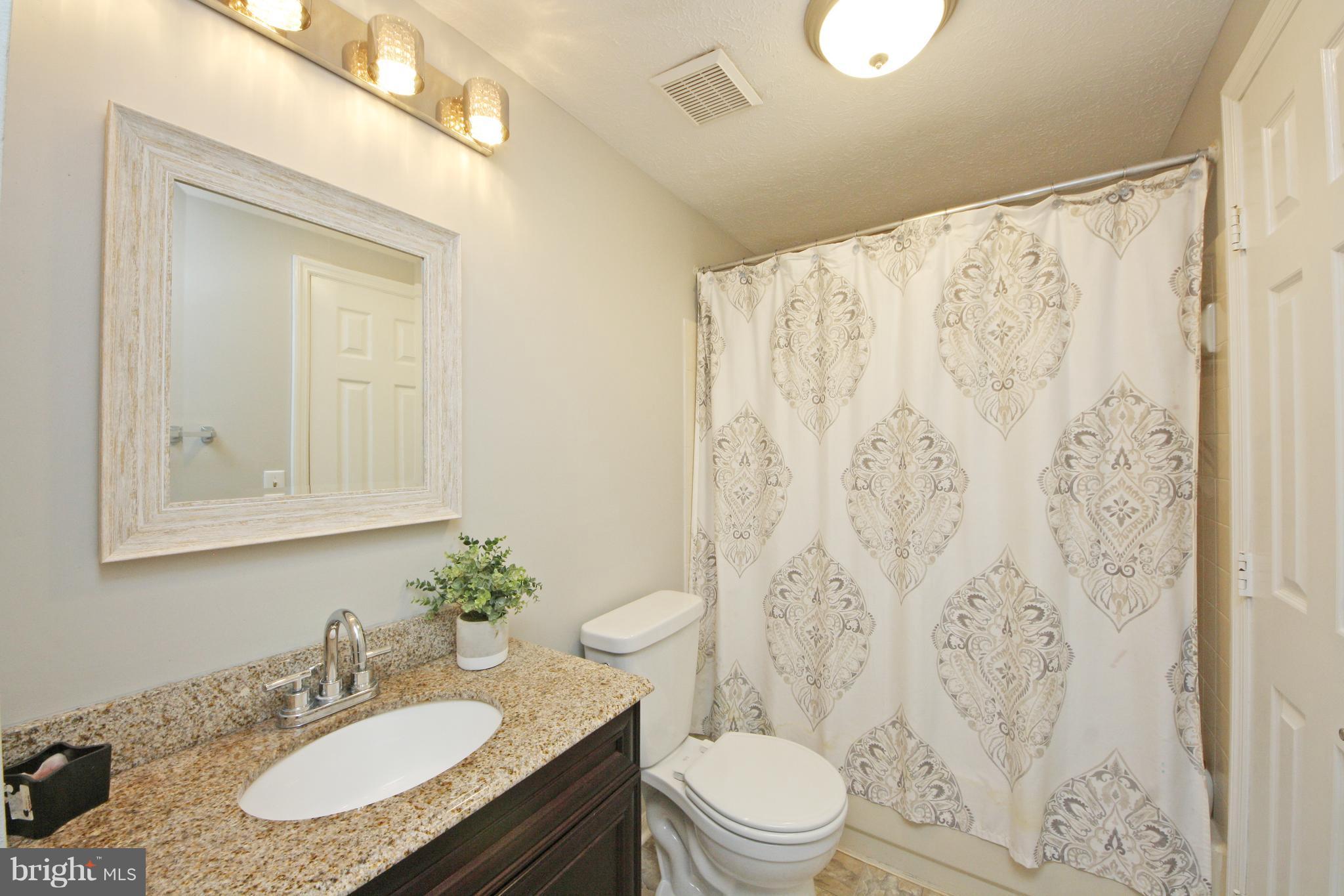 2152 Cedar Barn Way Baltimore, MD 21244 - Photo 24 of 29 a bathroom with a granite countertop sink a toilet and a mirror