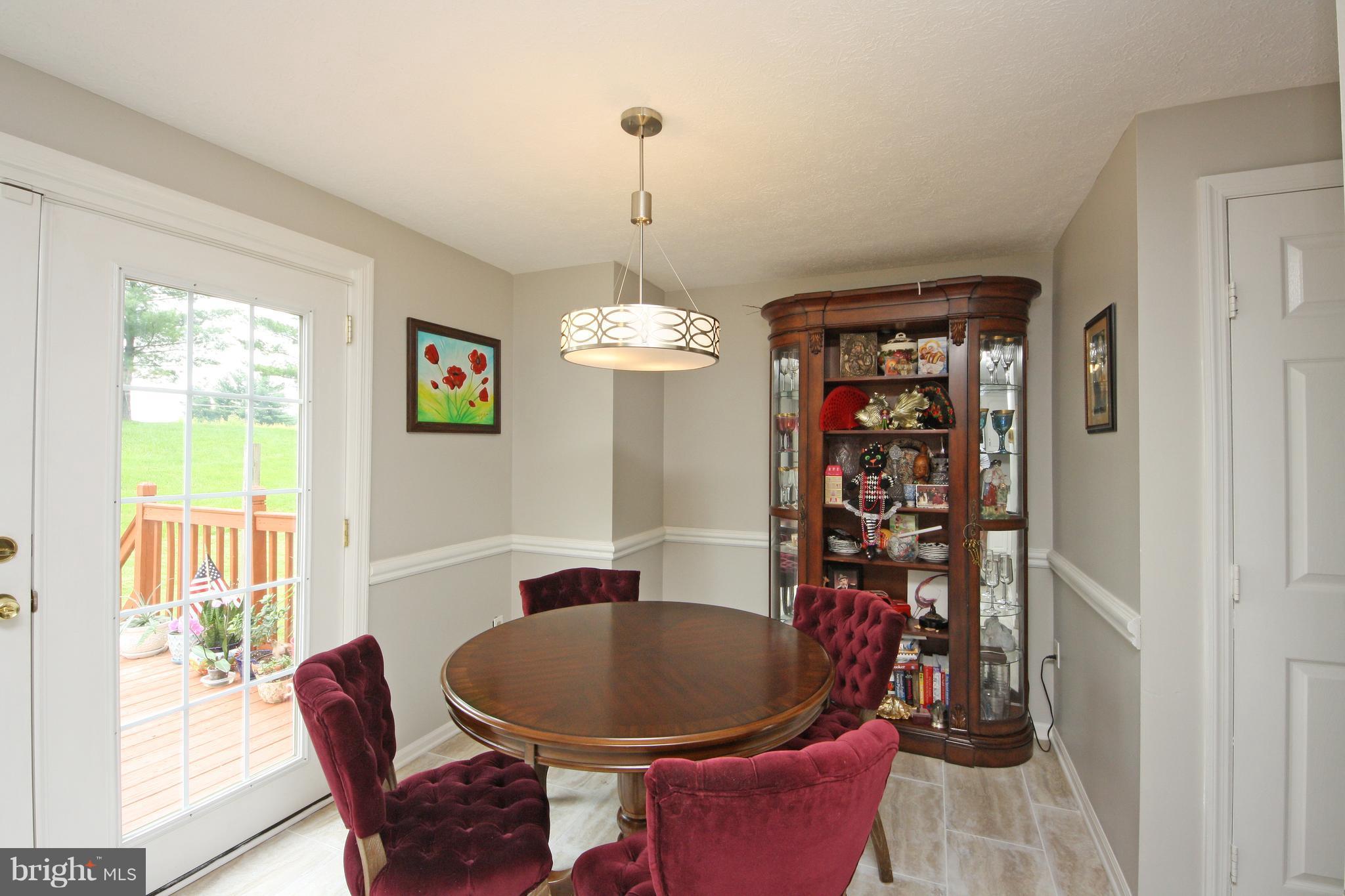 2152 Cedar Barn Way Baltimore, MD 21244 - Photo 4 of 29 a dining room with furniture a chandelier and window