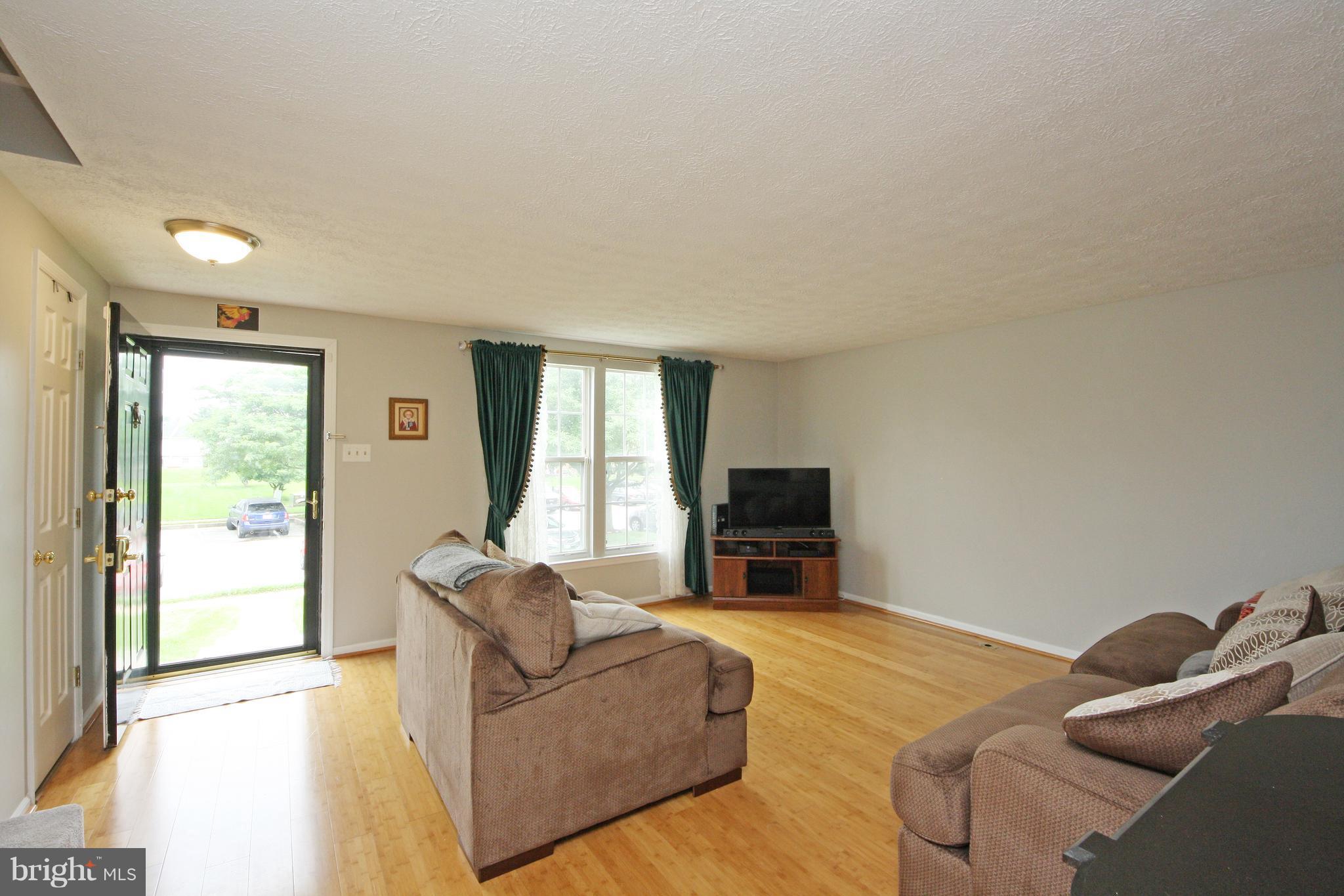 2152 Cedar Barn Way Baltimore, MD 21244 - Photo 10 of 29 a living room with furniture a fireplace and a flat screen tv