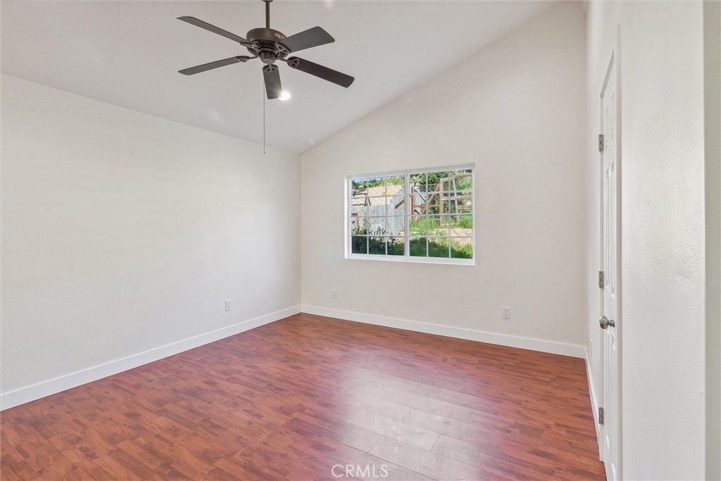 5153 Loma Verde Oceanside, CA 92056 - Photo 11 of 18 an empty room with wooden floor ceiling fan and windows