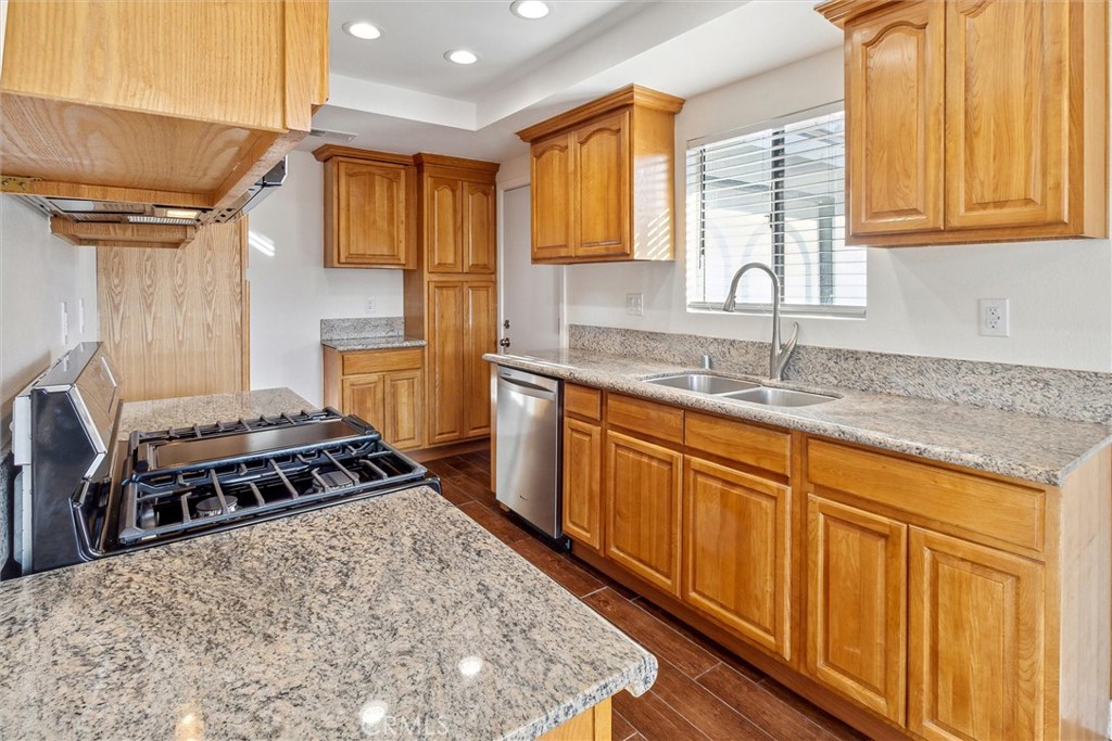 5153 Loma Verde Oceanside, CA 92056 - Photo 6 of 18 a kitchen with stainless steel appliances granite countertop a sink stove and refrigerator