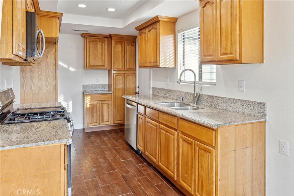 5153 Loma Verde Oceanside, CA 92056 - Photo 7 of 18 a kitchen with stainless steel appliances granite countertop a sink stove and cabinets