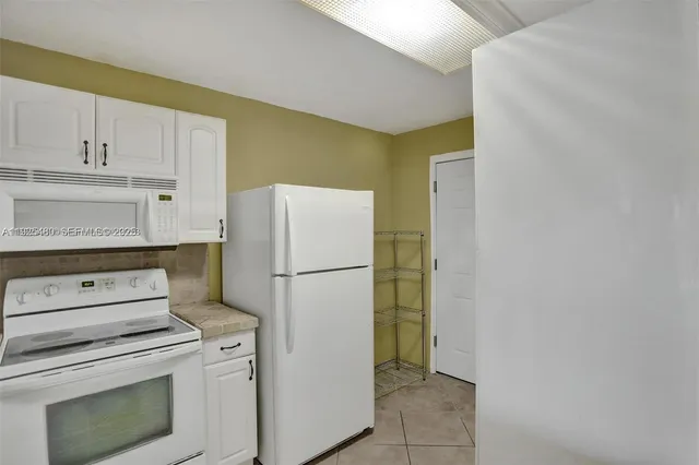a white refrigerator freezer and a stove sitting inside of a kitchen