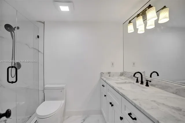 a bathroom with a toilet sink a mirror and shower