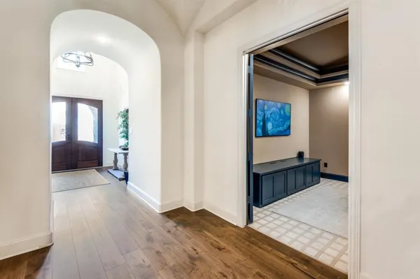 a view of hallway with livingroom and wooden floor