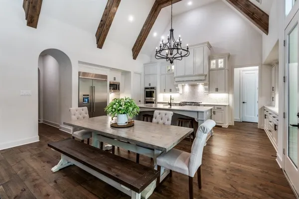 a view of a dining room with furniture a chandelier and wooden floor
