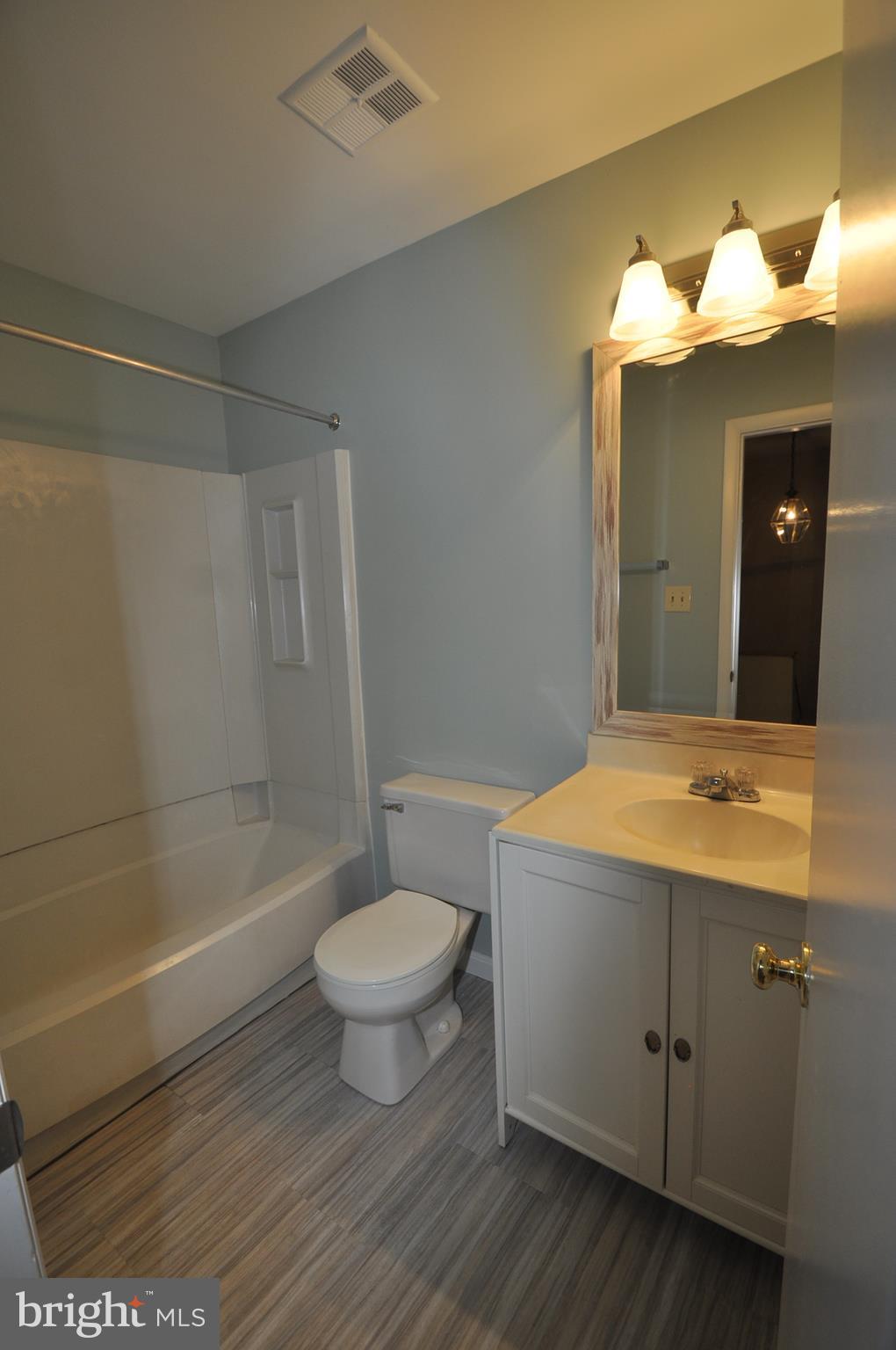 9125 Saffron Lane Silver Spring, MD 20901 - Photo 7 of 18 a bathroom with a sink a toilet a mirror and shower