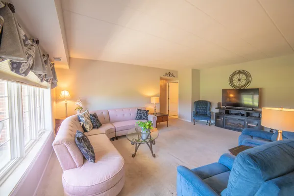 a living room with furniture a large window and a flat screen tv