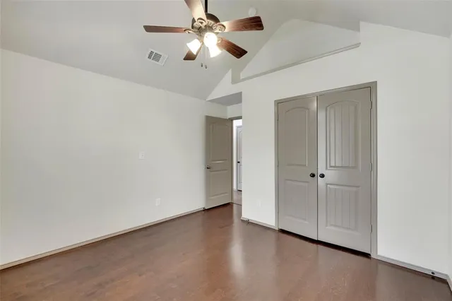 an empty room with a ceiling fan and a fan