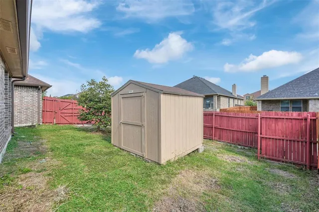 a view of a backyard with potted plants and wooden fence