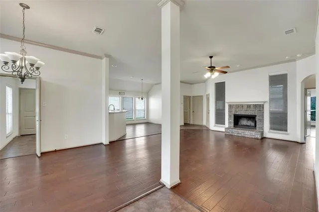 a view of a livingroom with wooden floor a fireplace and window