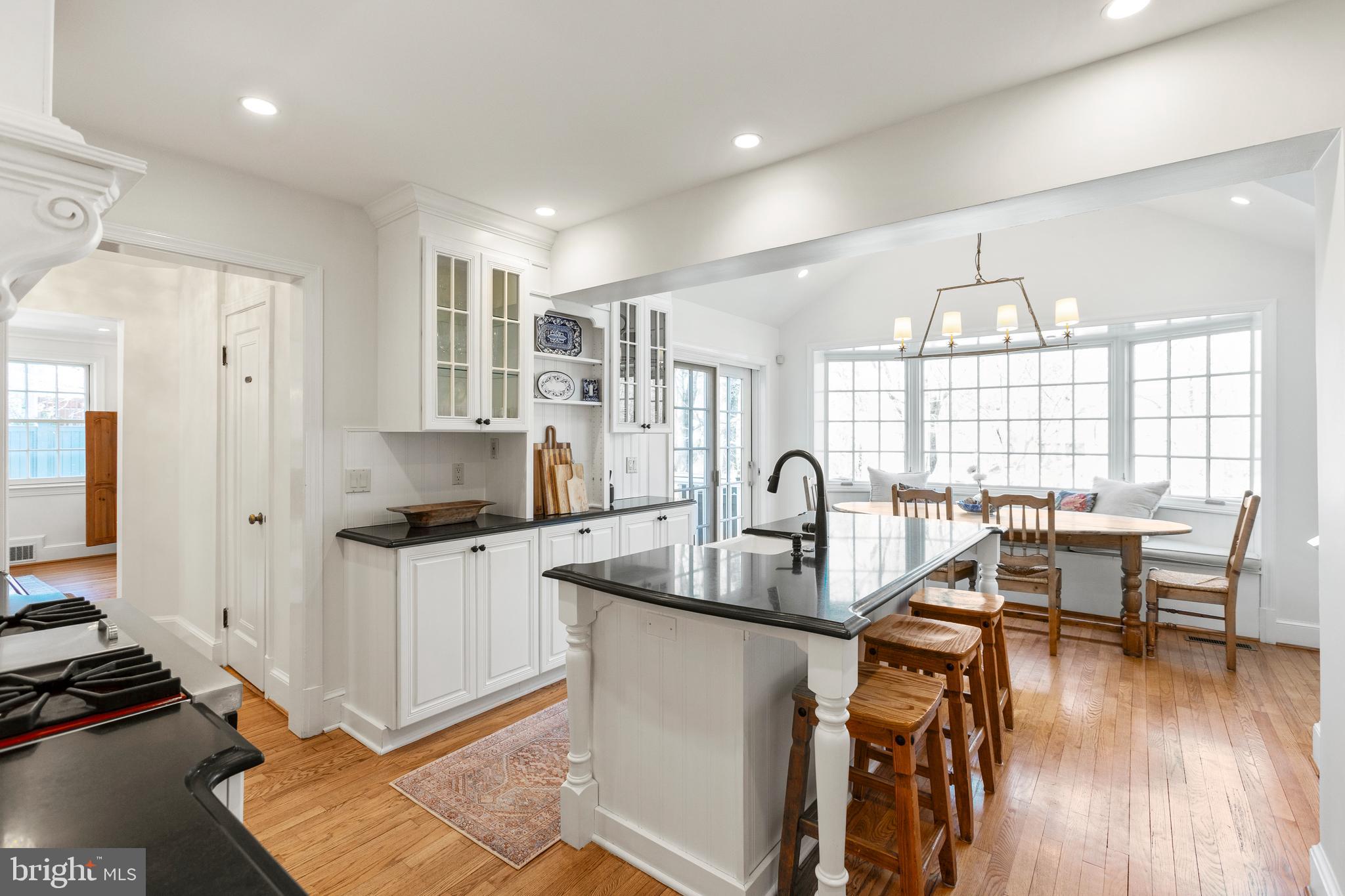 3303 Rolling Road Chevy Chase, MD 20815 - Photo 11 of 51 a kitchen with stainless steel appliances granite countertop a stove top oven a sink dishwasher and white cabinets with wooden floor