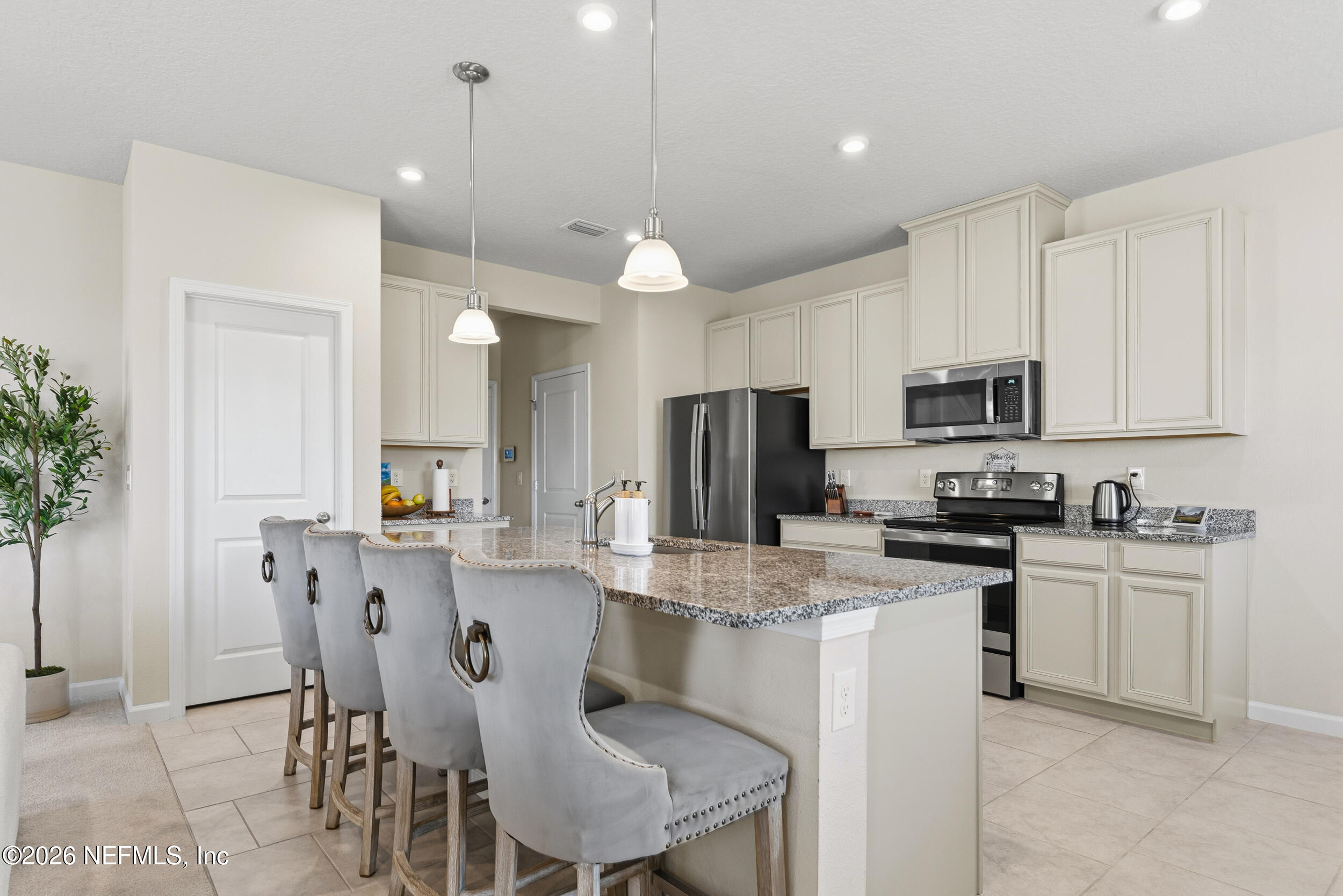 1052 Victoria Hills Jacksonville, FL 32221 - Photo 4 of 27 a kitchen with stainless steel appliances kitchen island granite countertop a stove a refrigerator a sink a dining table and chairs with wooden floor