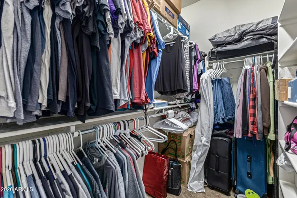a view of walk in closet with clothes