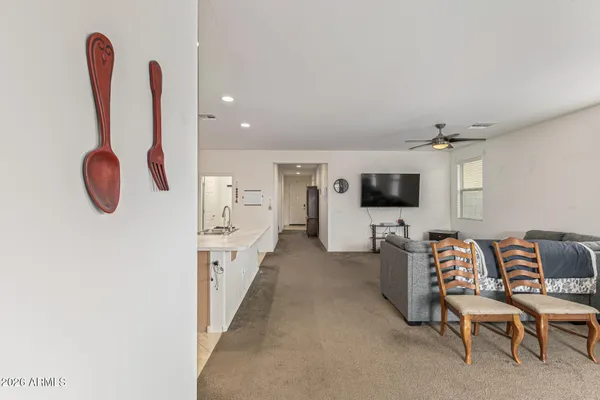 a living room with furniture a flat screen tv and kitchen island