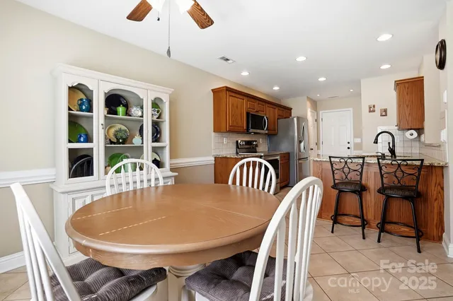 a large kitchen with stainless steel appliances granite countertop a stove a sink dishwasher a dining table and chairs with wooden floor