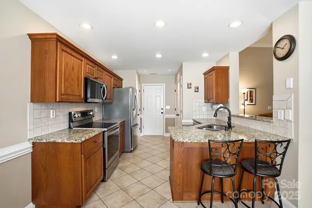 a kitchen with stainless steel appliances granite countertop a sink stove and refrigerator