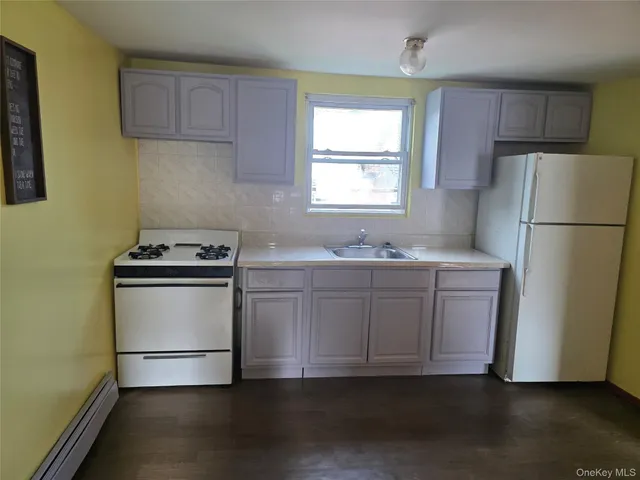 a kitchen with appliances a sink and a window