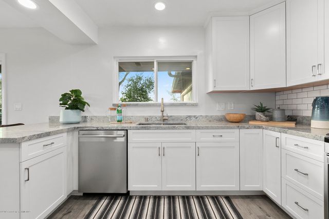 a kitchen with white cabinets and sink