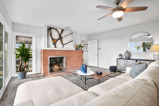 a living room with furniture a fireplace and a chandelier