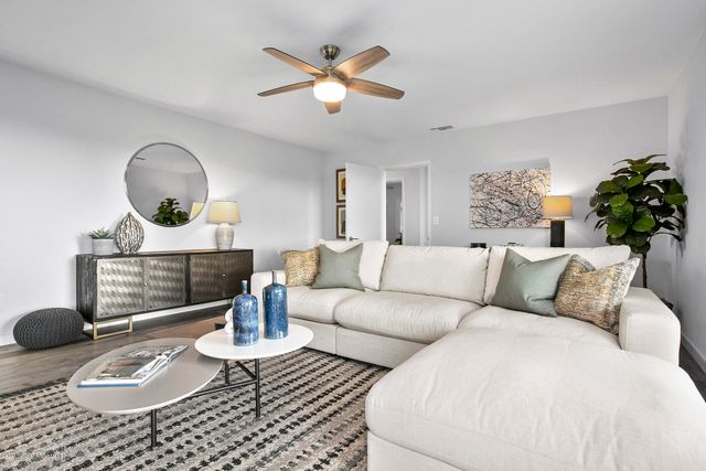 a living room with furniture a chandelier and a table