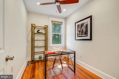 a view of a workspace with furniture and wooden floor