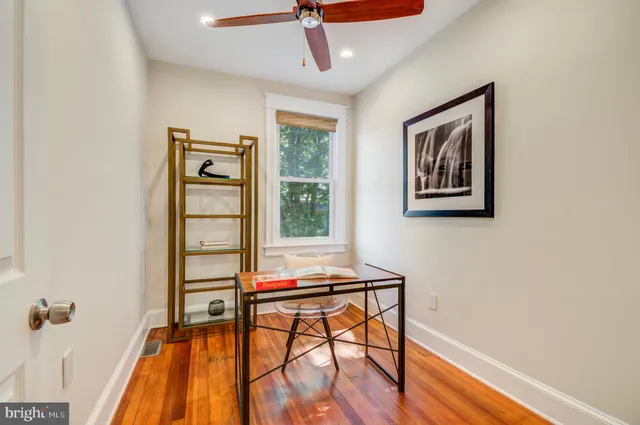 a view of a workspace with furniture and wooden floor