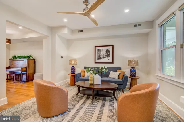 a living room with furniture a rug and a window