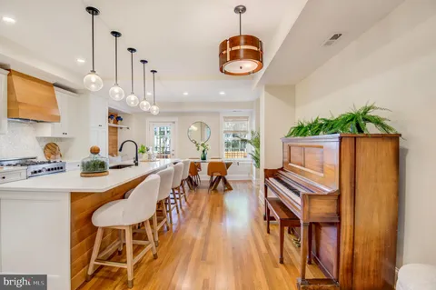 a kitchen with kitchen island granite countertop a sink a stove and cabinets