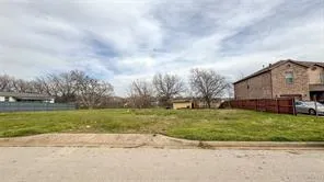 a view of a house with a big yard and a large trees