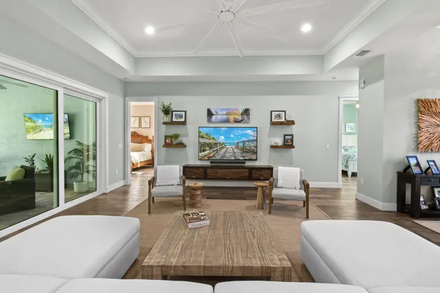 a kitchen with stainless steel appliances granite countertop a stove a refrigerator a microwave a sink and white cabinets with wooden floors