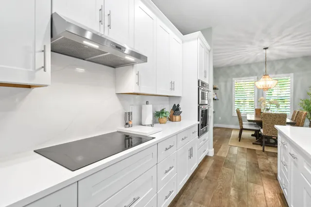 a view of a dining room with furniture wooden floor and chandelier