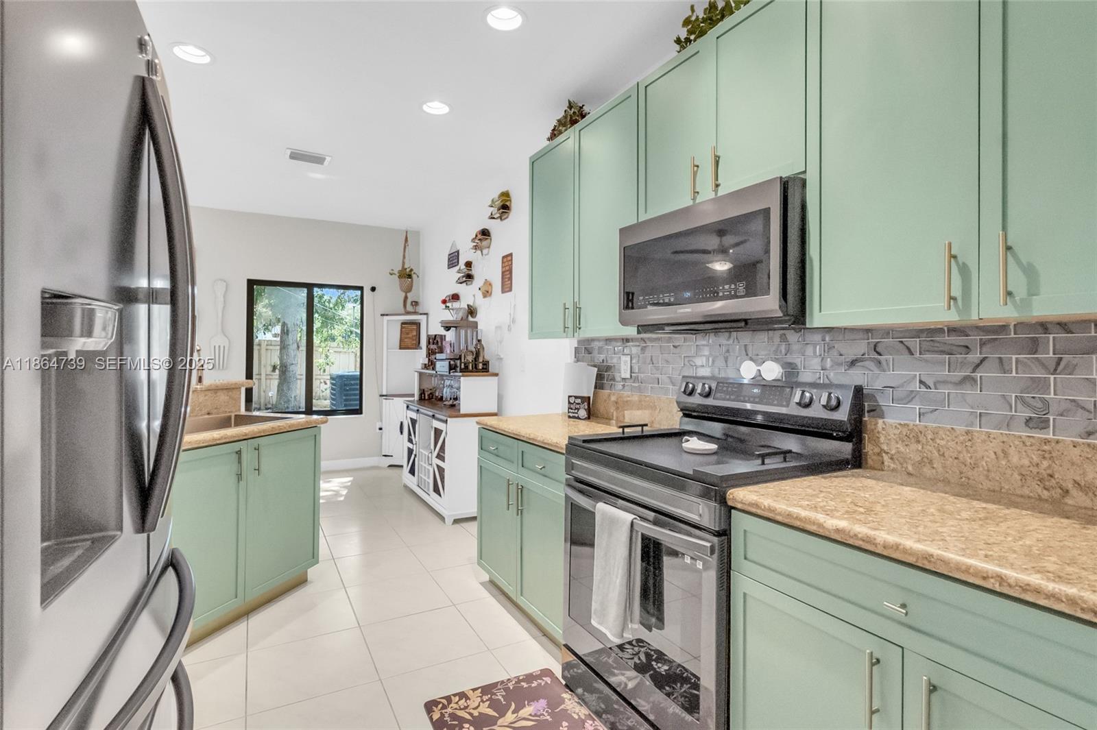 1635 Southeast 20th Terrace Homestead, FL 33035 - Photo 28 of 52 a kitchen with stainless steel appliances granite countertop a stove a sink and a microwave