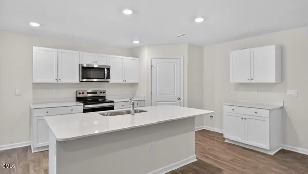 a kitchen with appliances a sink a counter space and cabinets
