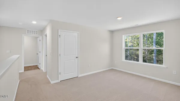 an empty room with windows and closet