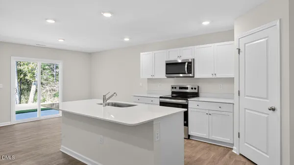 a kitchen with a sink stove top oven and microwave